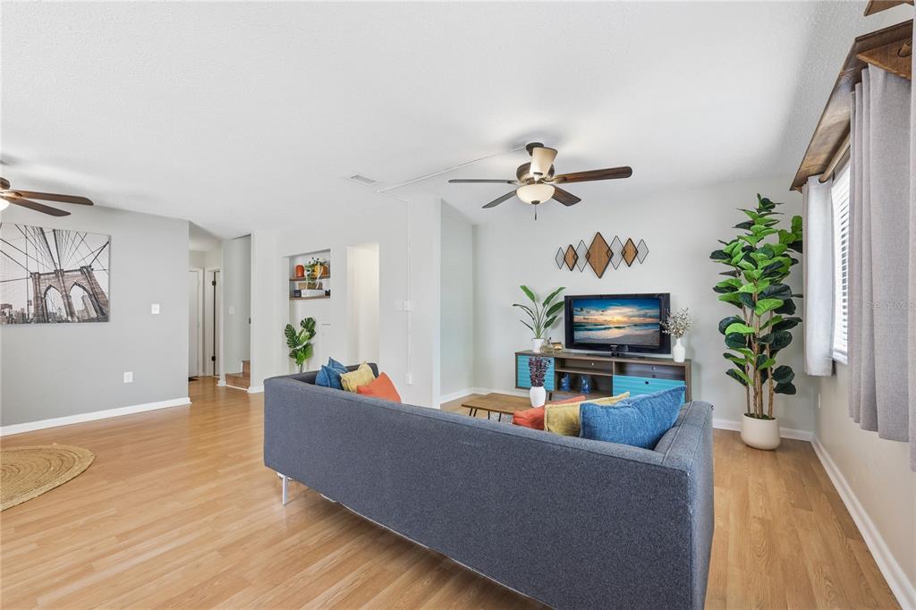 A living room features a gray sofa, a television on a console, and light wood flooring — 4109 NW 43RD TERRACE UNIT 69, GAINESVILLE, FL