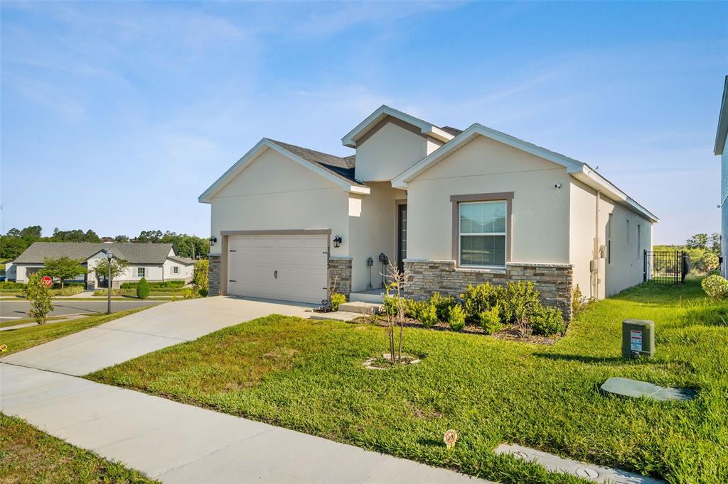 A screened-in porch features two wooden rocking chairs, a small bistro set, and outdoor views — 1553 FLEUR DRIVE, DAVENPORT, FL