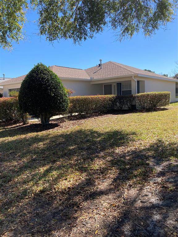 A single-story house with a light-colored exterior, a shingled roof, and manicured landscaping — 9505 SW 93 LOOP, OCALA, FL