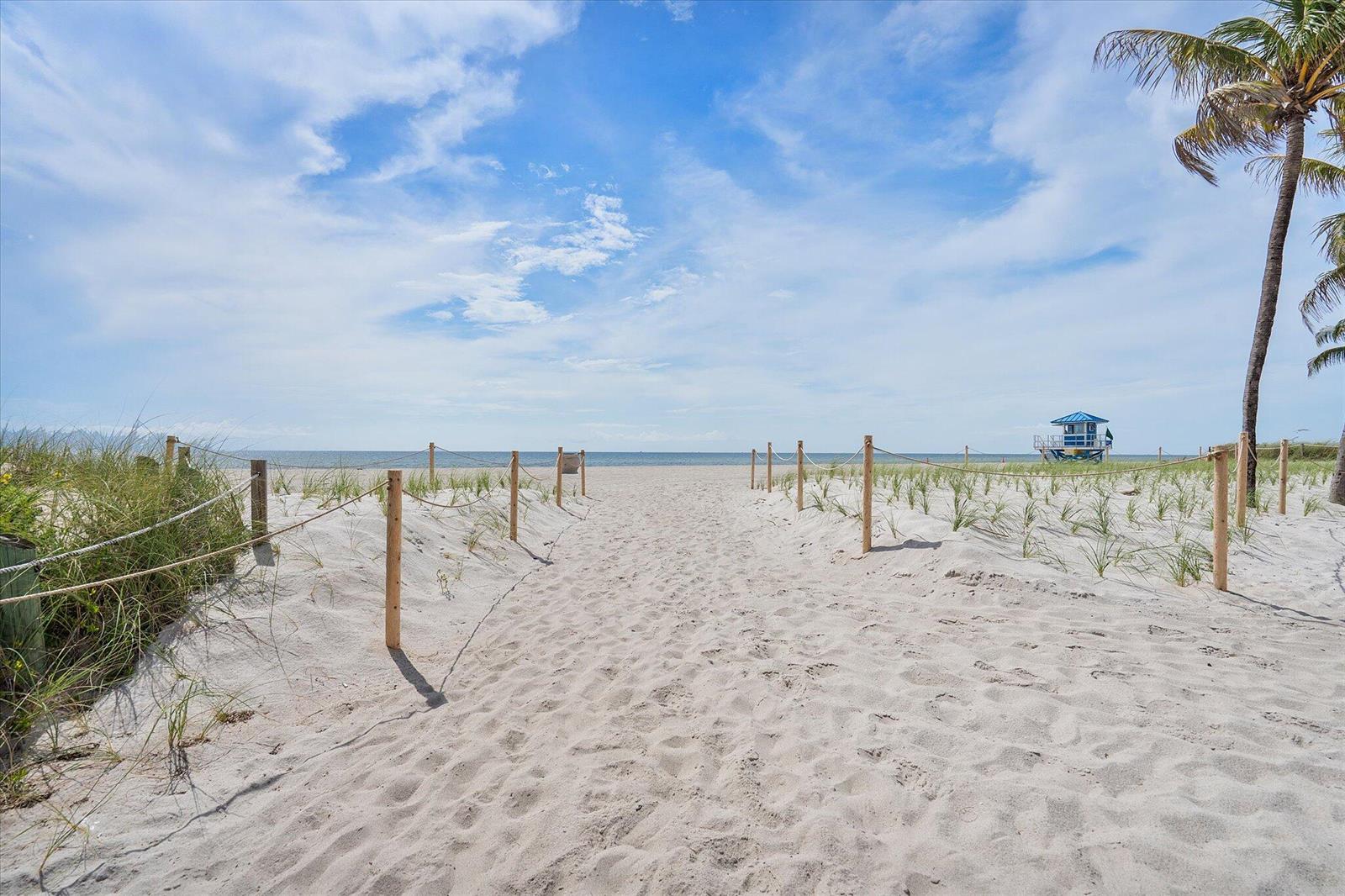 A sandy path leads through dunes toward the ocean with a lifeguard tower in view — 1601 S Ocean Drive # 506, Hollywood FL 33019, HOLLYWOOD, FL