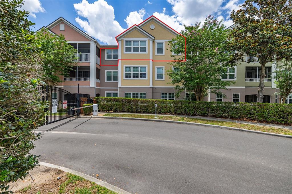 A three-story apartment building with a gated entrance and a paved driveway in front — 3315 PARKCHESTER SQUARE BOULEVARD UNIT 304, ORLANDO, FL