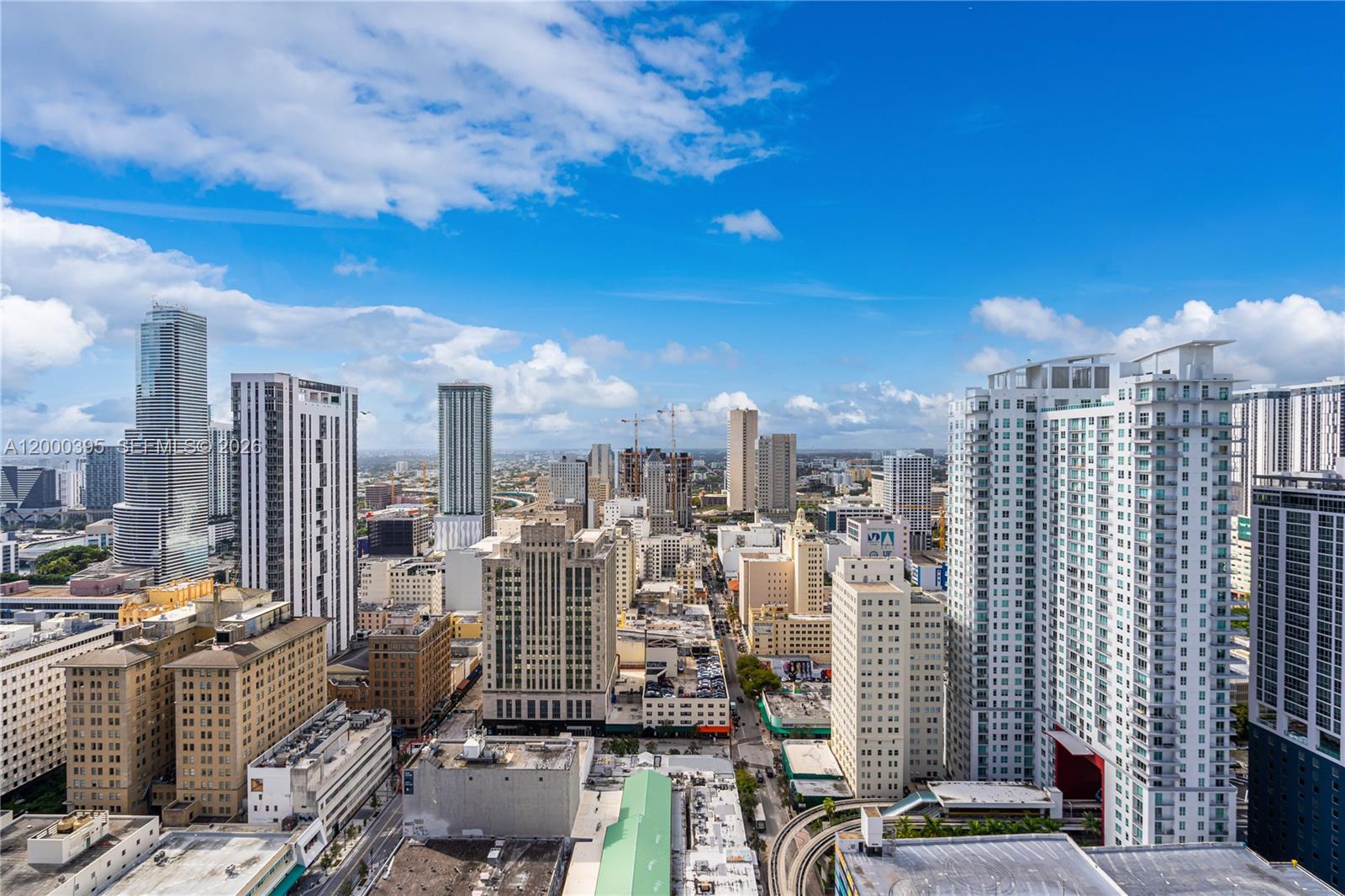 An elevated view of a dense urban skyline featuring numerous high-rise buildings under a blue sky — 50 Biscayne Blvd # 3601, Miami FL 33132, MIAMI, FL