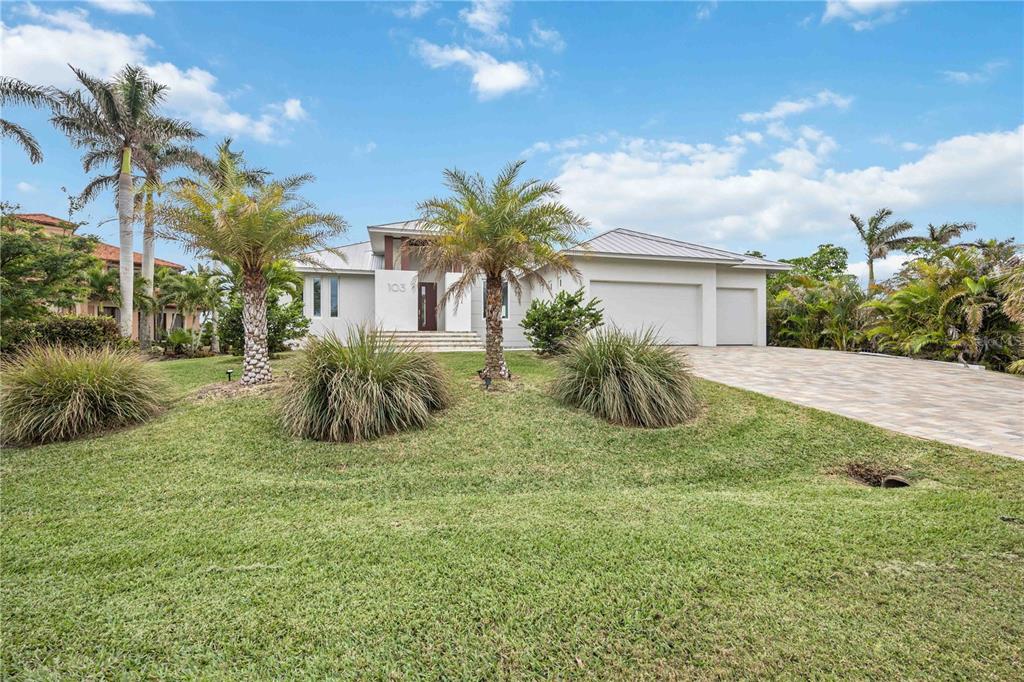 A single-story house with a paved driveway, palm trees, and a grassy front lawn — 103 GRAHAM STREET SE, PORT CHARLOTTE, FL