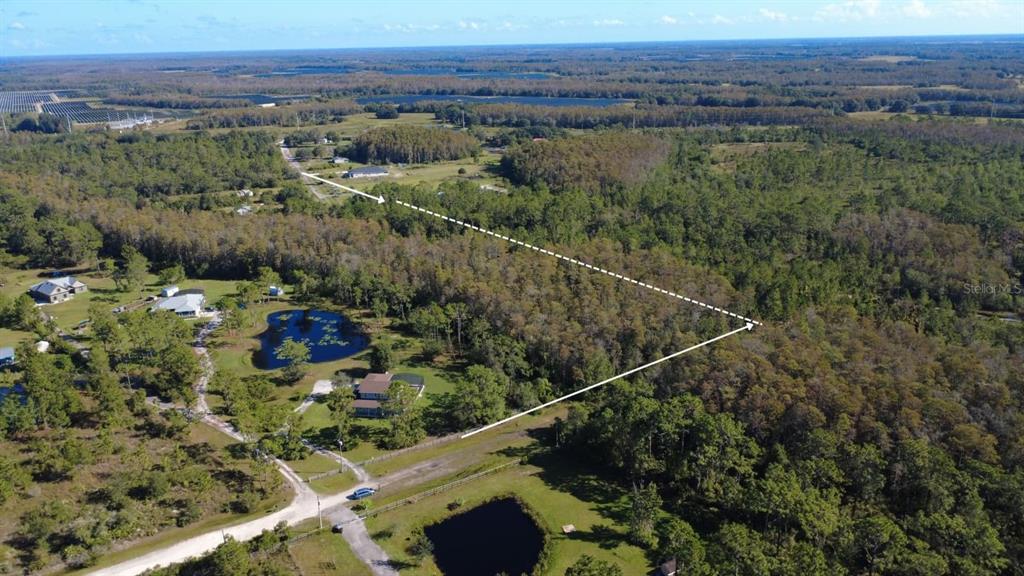 An aerial view shows a rural property with houses, ponds, and a large wooded area — 0 CYPRESS CREEK RANCH ROAD, ST CLOUD, FL