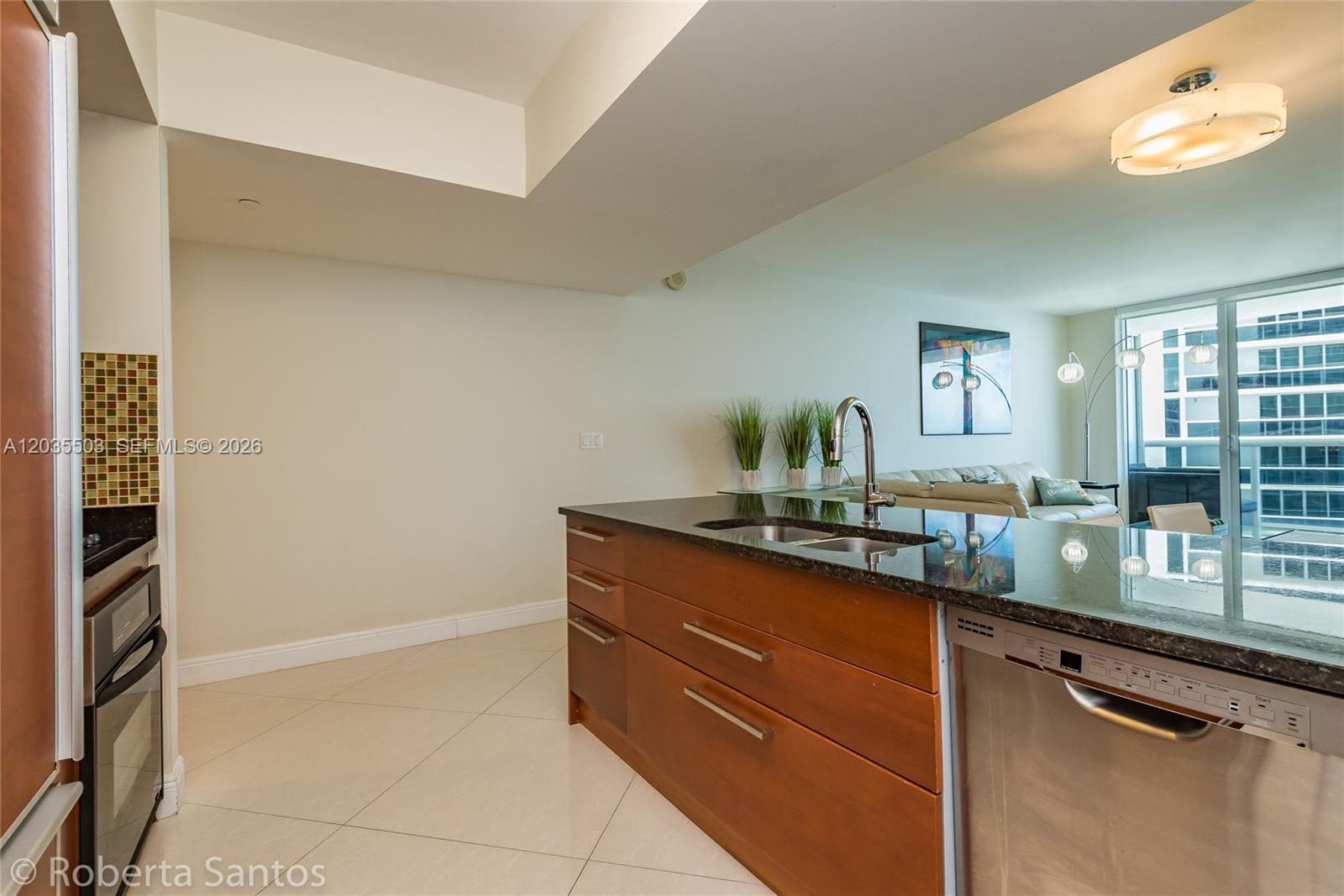 A kitchen features a wooden island with a dark countertop and stainless steel appliances — 1830 S Ocean Dr # 2410, Hallandale Beach FL 33009, HALLANDALE BEACH, FL