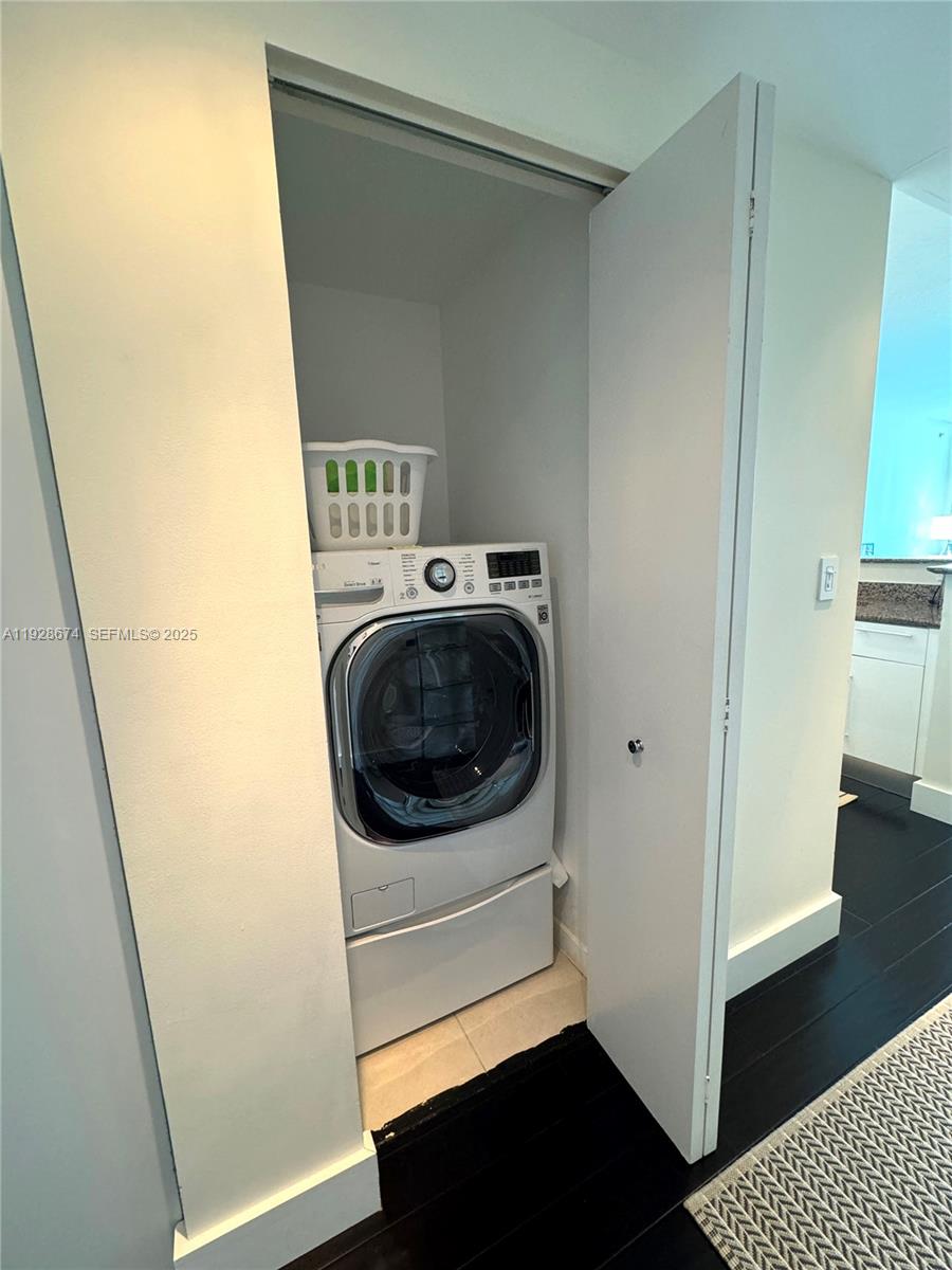 A white front-loading washing machine is located inside a small closet — 335 S Biscayne Blvd # 2403, Miami FL 33131, MIAMI, FL