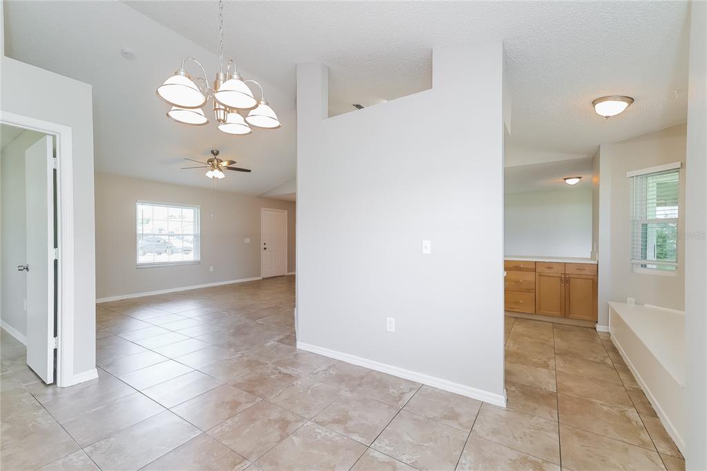 An interior view shows a tiled living area with a chandelier, ceiling fan, and vanity — 177 TORTUGA COURT, DAVENPORT, FL