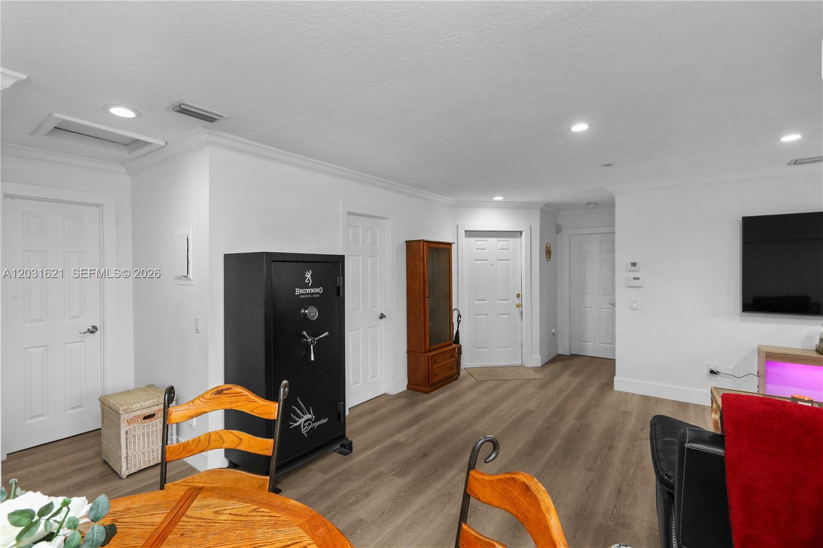 A living area features light wood-look flooring, white walls, multiple interior doors, and a large safe — 15240 SW 45th Ter # H, Miami FL 33185, MIAMI, FL