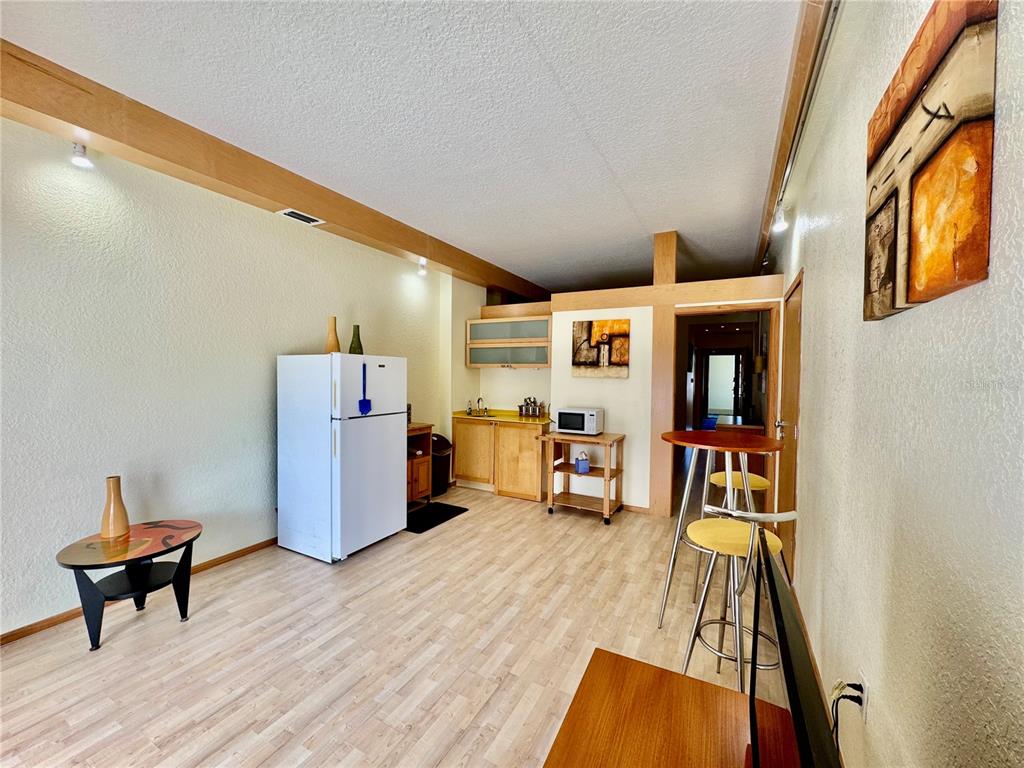 A small kitchen area features light wood cabinets, a white refrigerator, and a breakfast bar — 101 PALM HARBOR PARKWAY UNIT 228 B, PALM COAST, FL