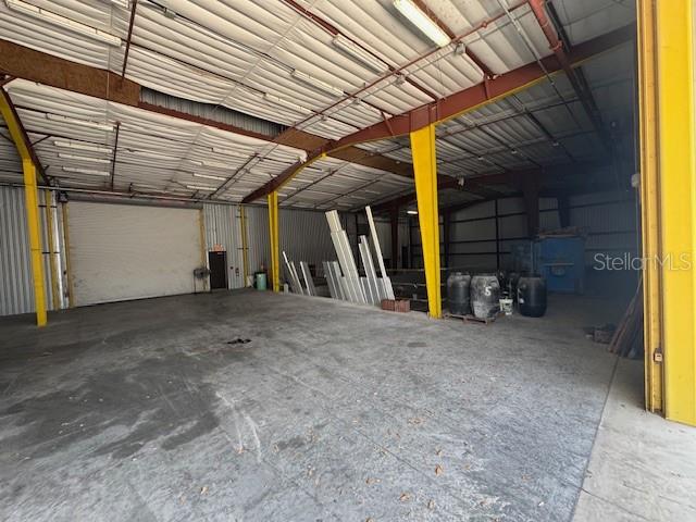 An expansive, open-concept industrial warehouse space features concrete flooring, exposed metal beams, and large doors — 2251 TOPLINE WAY UNIT 6, BROOKSVILLE, FL