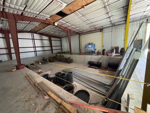 An industrial warehouse interior features a concrete loading dock, metal walls, and exposed steel beams — 2251 TOPLINE WAY UNIT 6, BROOKSVILLE, FL