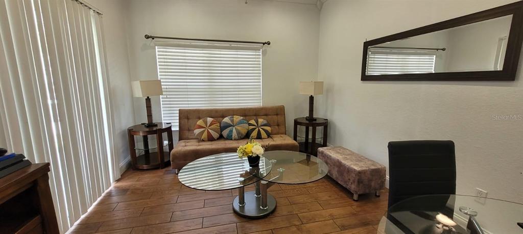 A living room features a brown sofa, glass coffee table, two side tables, and tile flooring — 4004 SANTA MARIA DRIVE UNIT 101, KISSIMMEE, FL