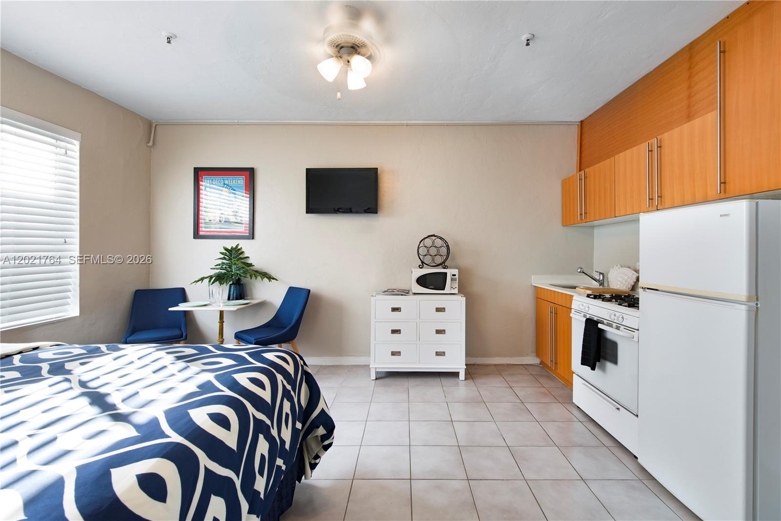 A studio apartment features a bed, a small dining area, and a kitchenette with cabinets — 3710 Collins Ave # 305, Miami Beach FL 33140, MIAMI BEACH, FL