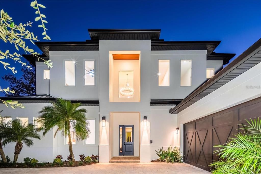 A modern two-story house exterior features a central recessed entryway, white stucco, and dark accents — 2420 FLOYD STREET, SARASOTA, FL