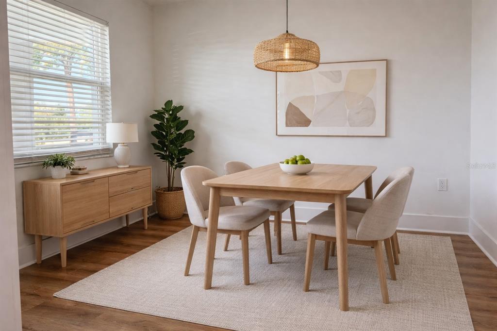 A dining room features a light wood table, four upholstered chairs, and a woven pendant light — 1001 77TH AVENUE N UNIT 102, ST PETERSBURG, FL