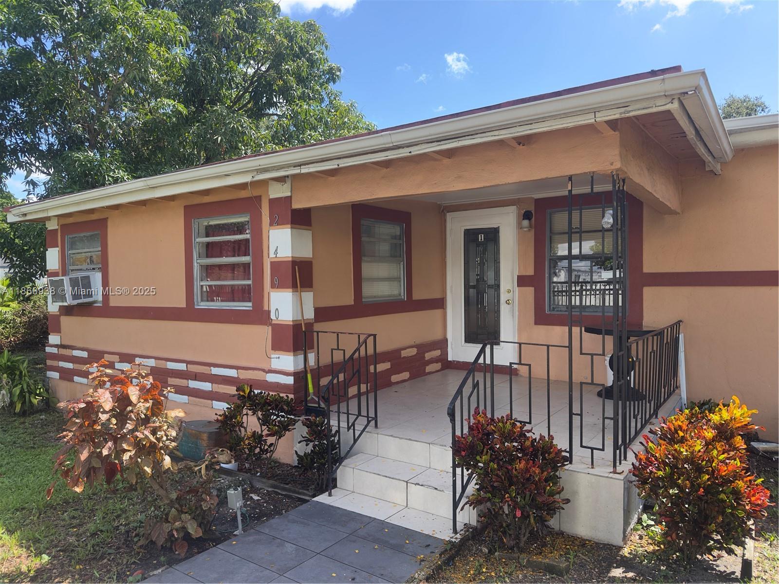 A single-story house with a covered porch, metal railings, and a tan and red exterior — 2490 NW 97th St # A, Miami FL 33147, MIAMI, FL
