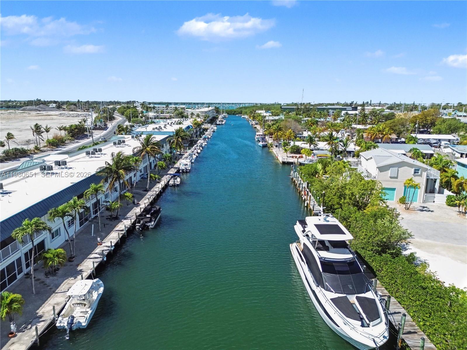An aerial view shows a narrow canal lined with docked boats and residential buildings — 5301 Ocean Ter # 7, Marathon FL 33050, MARATHON, FL
