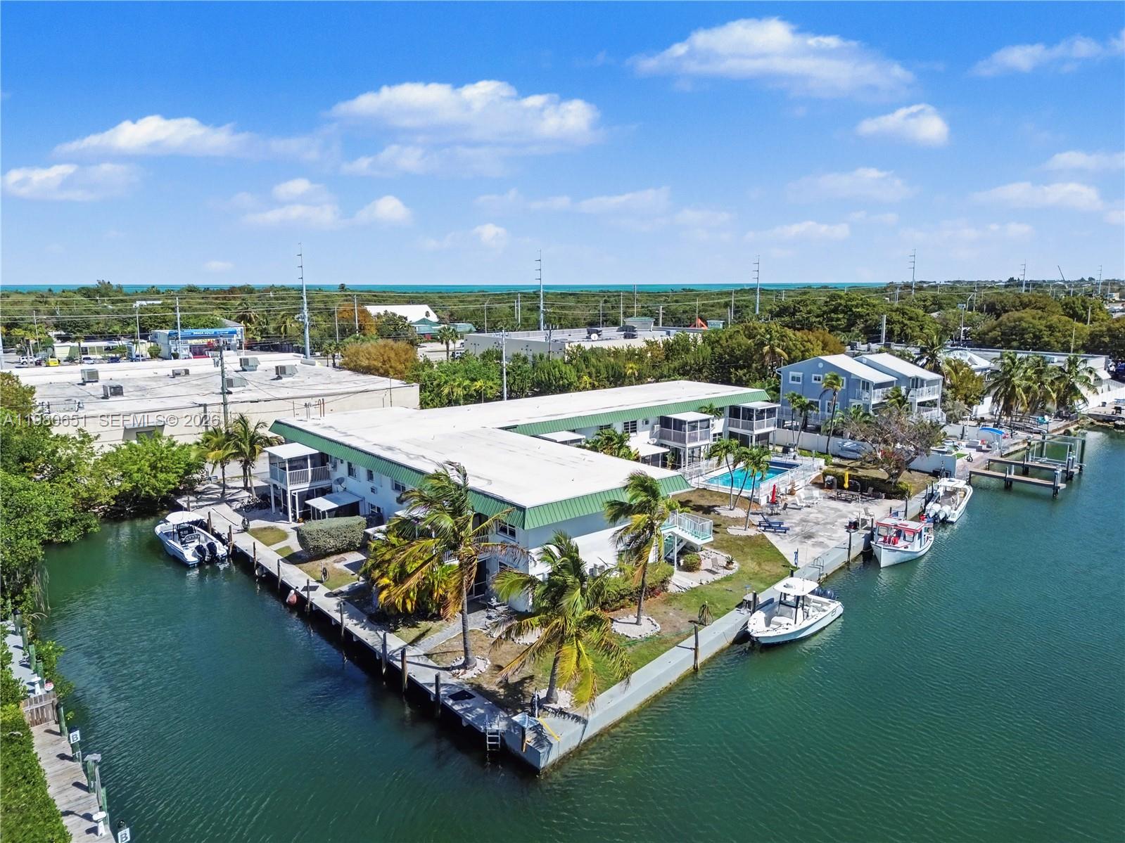 An aerial view shows a waterfront apartment complex with a pool and private boat docks — 5301 Ocean Ter # 7, Marathon FL 33050, MARATHON, FL