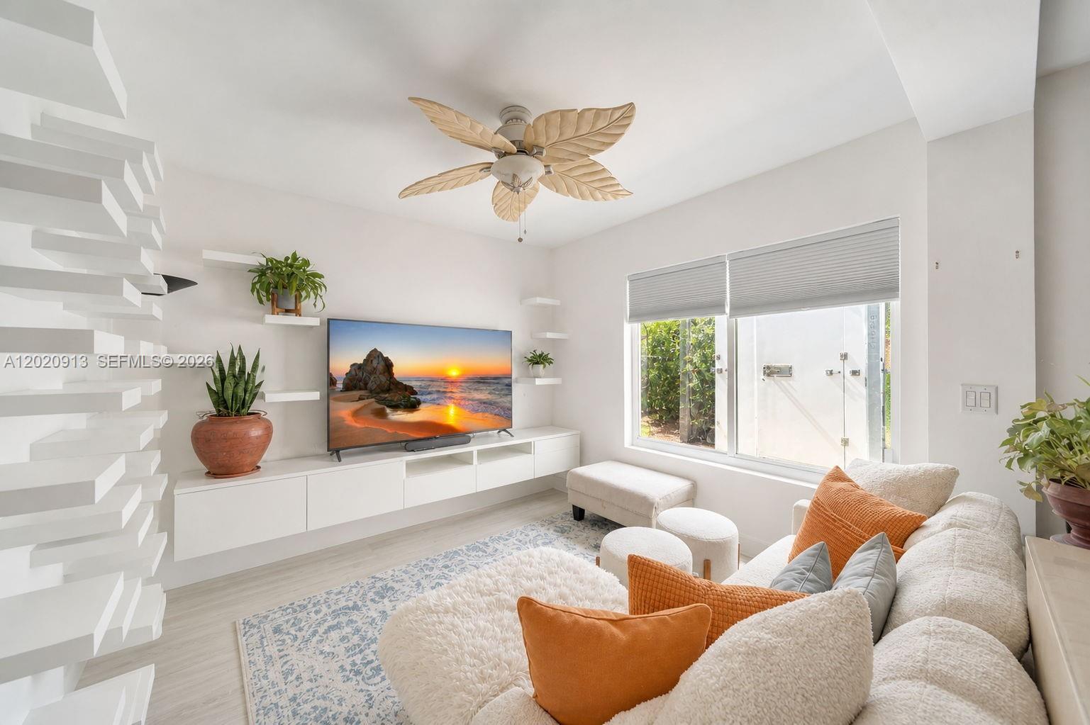 A bright living room features a white floating media console, a palm-leaf ceiling fan, and sofa — 860 NE 127TH ST, North Miami FL 33161, NORTH MIAMI, FL