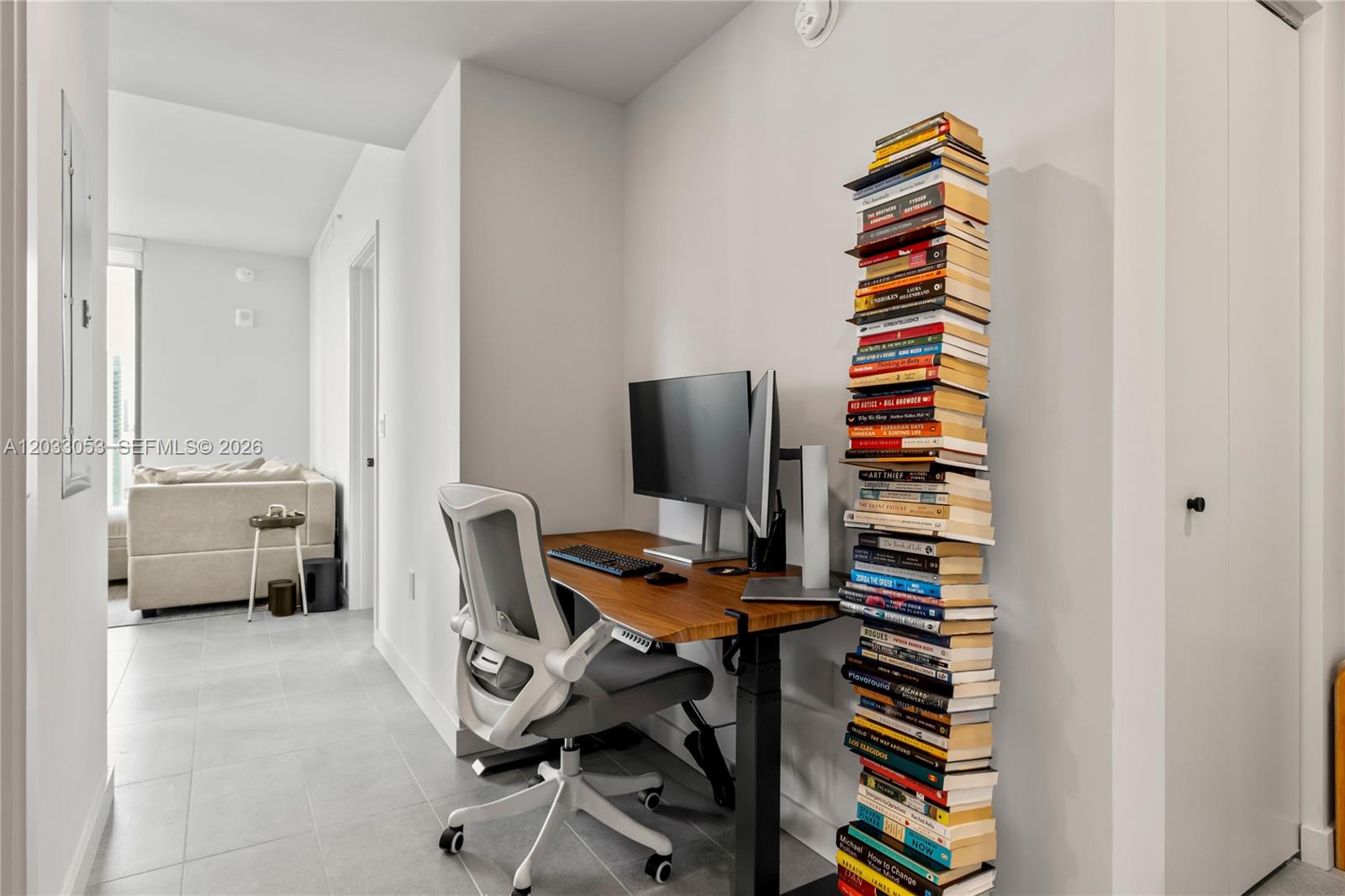 A home office nook features a standing desk, an ergonomic chair, and a tall vertical bookshelf — 121 NE 5th St # 2401, Miami FL 33132, MIAMI, FL