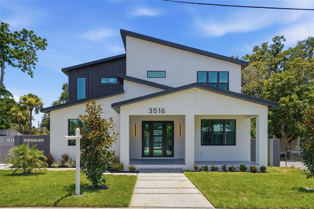 A modern two-story house features a white exterior, dark metal accents, and a covered porch — 3516 21ST AVENUE S, ST PETERSBURG, FL