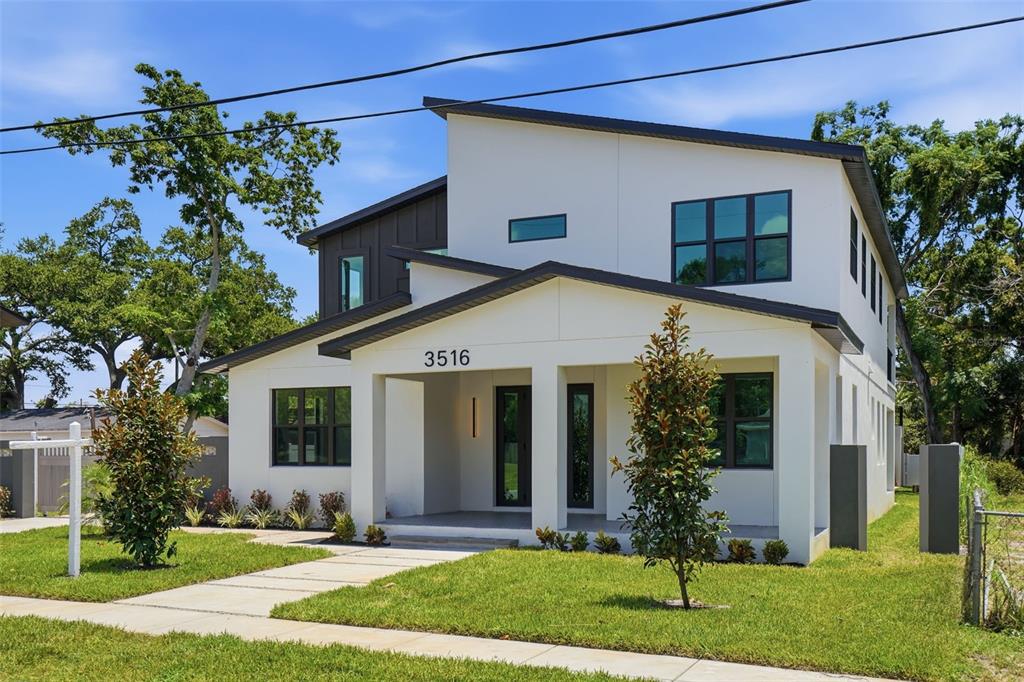 A modern two-story house with white stucco walls, dark trim, and a covered front porch — 3516 21ST AVENUE S, ST PETERSBURG, FL