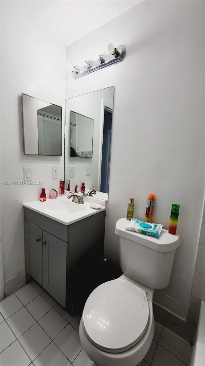 A small bathroom features a gray vanity, a wall mirror, and a white toilet — 6960 NW 174th Ter # 706, Hialeah FL 33015, HIALEAH, FL