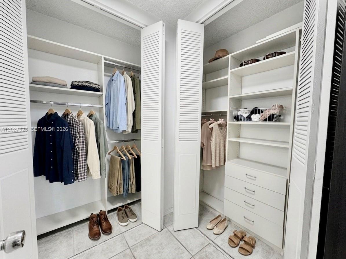A walk-in closet features white louvered doors, built-in shelving, hanging rods, and a four-drawer dresser — 800 West Ave # 924, Miami Beach FL 33139, MIAMI BEACH, FL