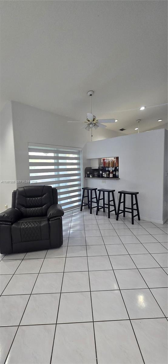 A living area features white tile floors, a black leather recliner, and a breakfast bar — 10001 SW 218th St, Cutler Bay FL 33190, CUTLER BAY, FL