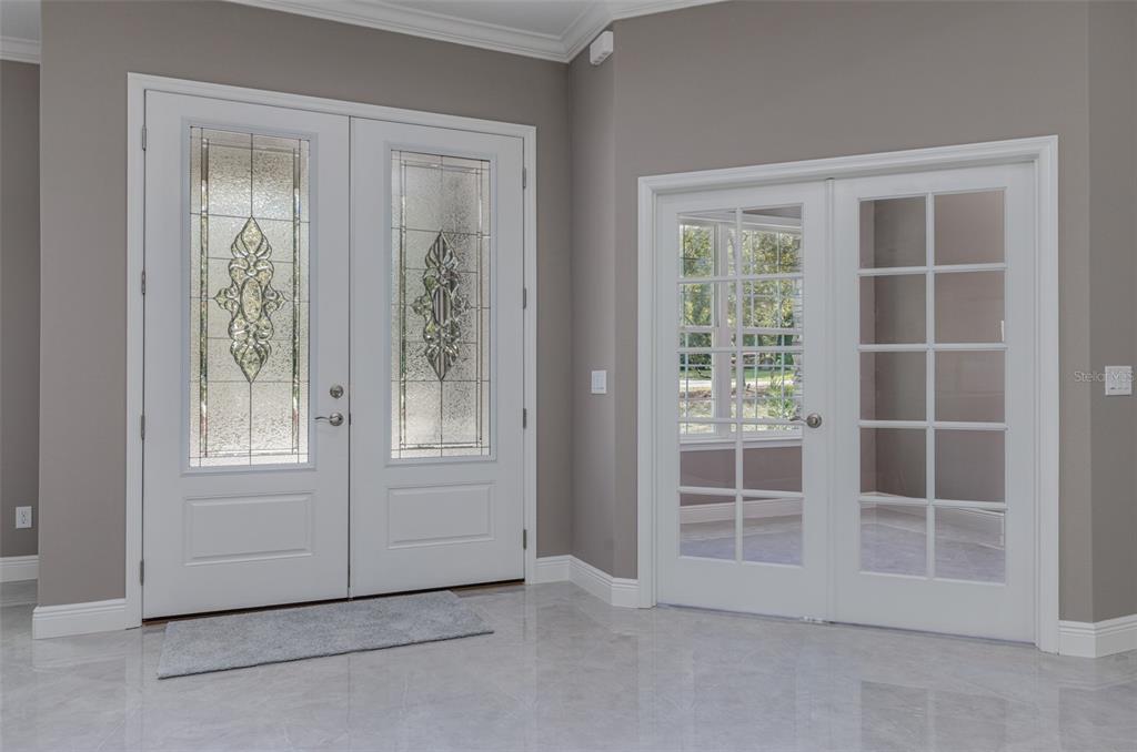 An entryway features white double front doors with decorative glass and adjacent French doors — 5924 N ROSEBARK WAY, BEVERLY HILLS, FL
