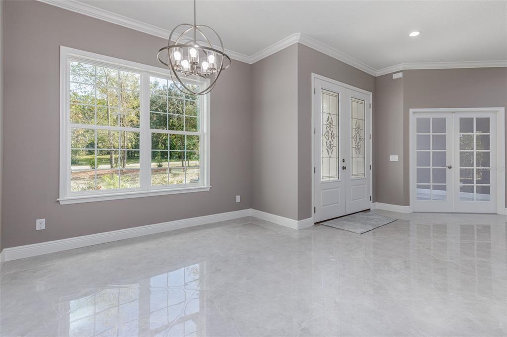 A bright dining room features gray walls, a globe chandelier, and polished light-colored tile flooring — 5924 N ROSEBARK WAY, BEVERLY HILLS, FL