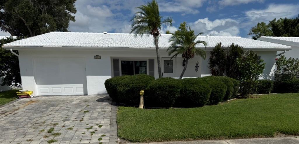 A white, single-story house with a tiled roof, a paved driveway, and palm trees — 9021 41ST WAY N UNIT 0, PINELLAS PARK, FL
