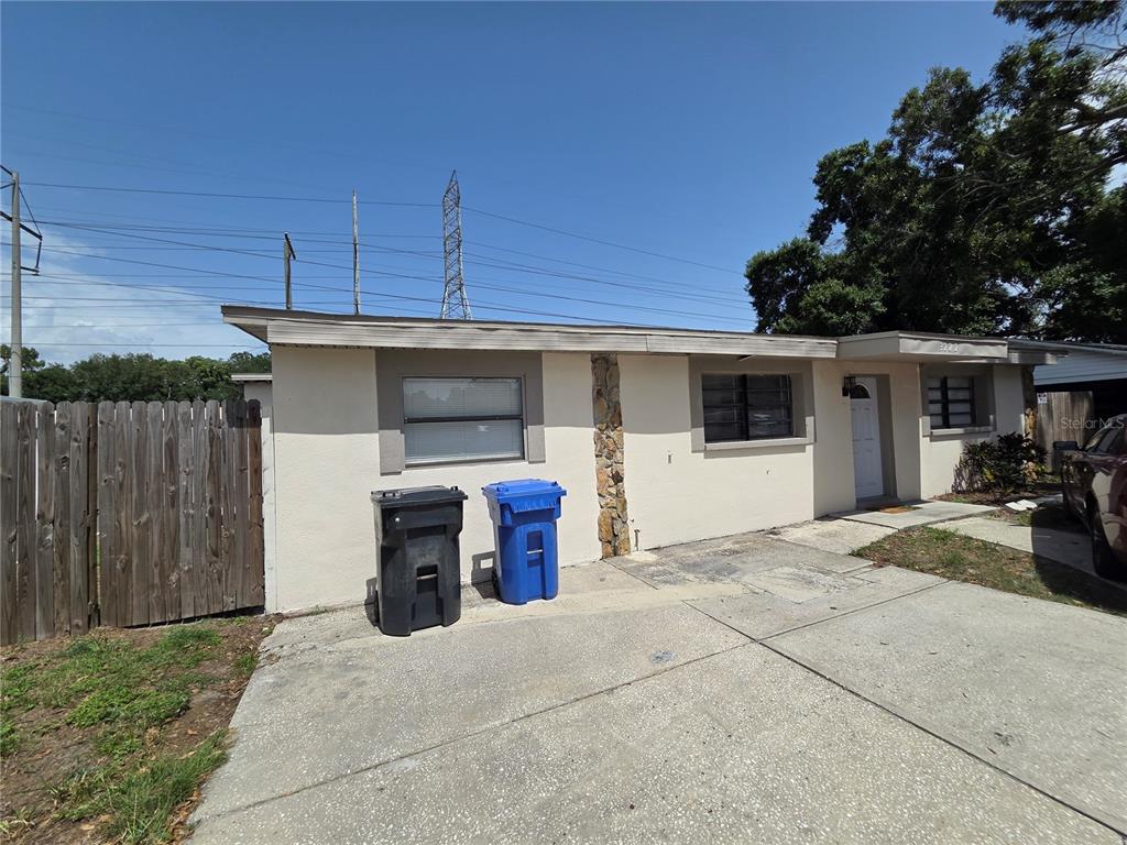 An empty room features white walls, exposed ceiling beams, and light-colored wood-look flooring — 3222 WELBORN WAY, TAMPA, FL