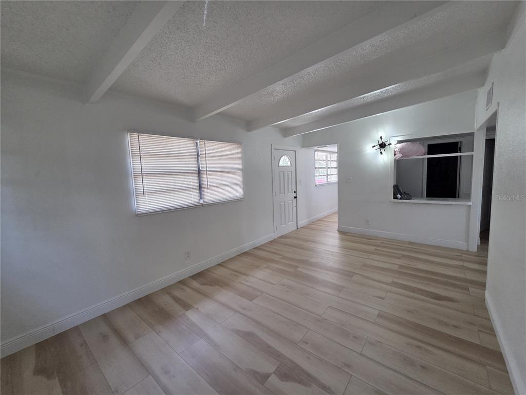 A galley kitchen features white cabinets, black appliances, a subway tile backsplash, and wood flooring — 3222 WELBORN WAY, TAMPA, FL