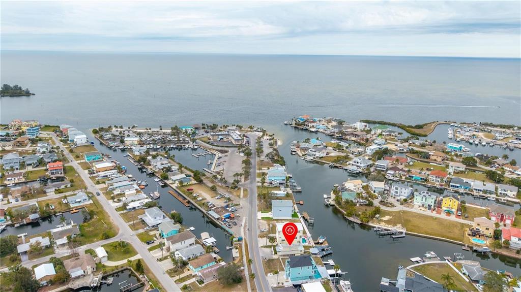 An aerial view shows a coastal neighborhood with houses along canals leading to the ocean — 6501 CLARK STREET, HUDSON, FL