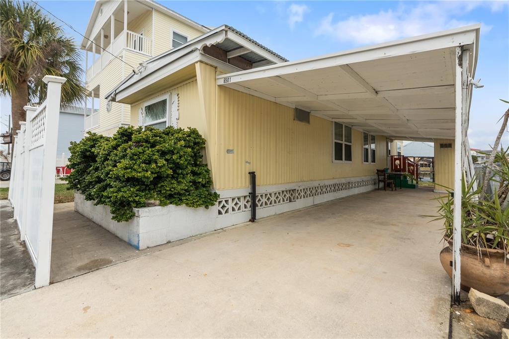 A yellow mobile home with a carport and a white lattice fence — 6501 CLARK STREET, HUDSON, FL