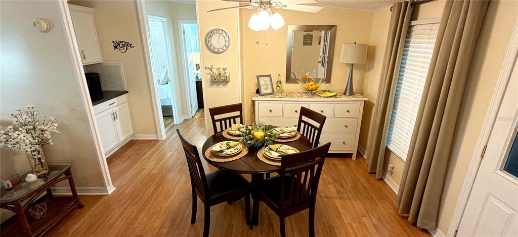 A dining area features a round wooden table with four chairs and a white sideboard — 161 GREENVIEW DRIVE UNIT 161, WINTER HAVEN, FL