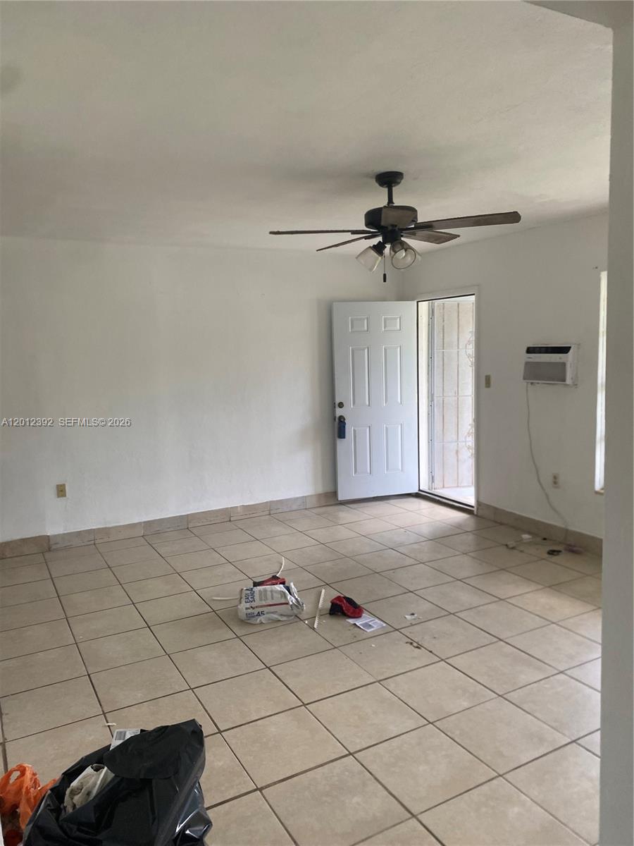 A room with white walls, tiled flooring, a ceiling fan, and an open doorway — 1070 NW 147th St, Miami FL 33168, MIAMI, FL
