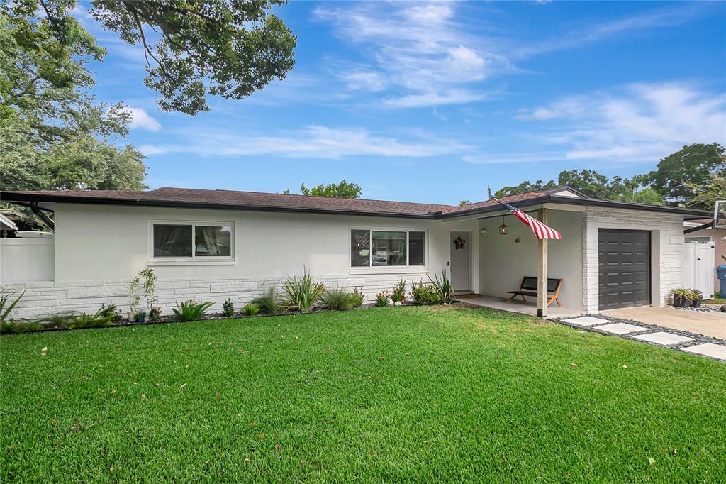A single-story house with white stucco walls, a stone base, and a front-facing garage — 510 HILLCREST DRIVE, LARGO, FL