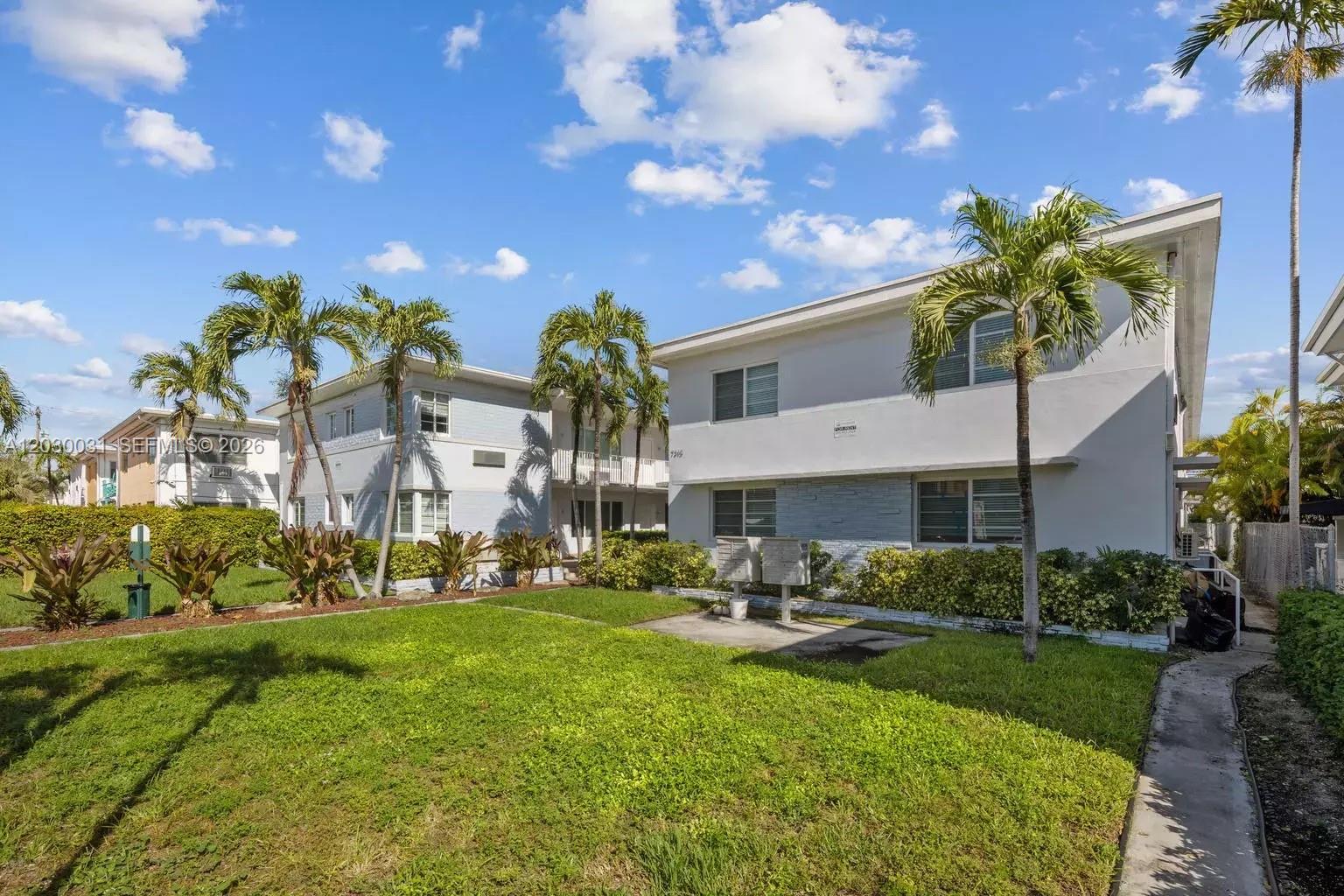 A two-story apartment building with a grassy lawn, palm trees, and a concrete walkway — 7325 Carlyle Ave # 2, Miami Beach FL 33141, MIAMI BEACH, FL