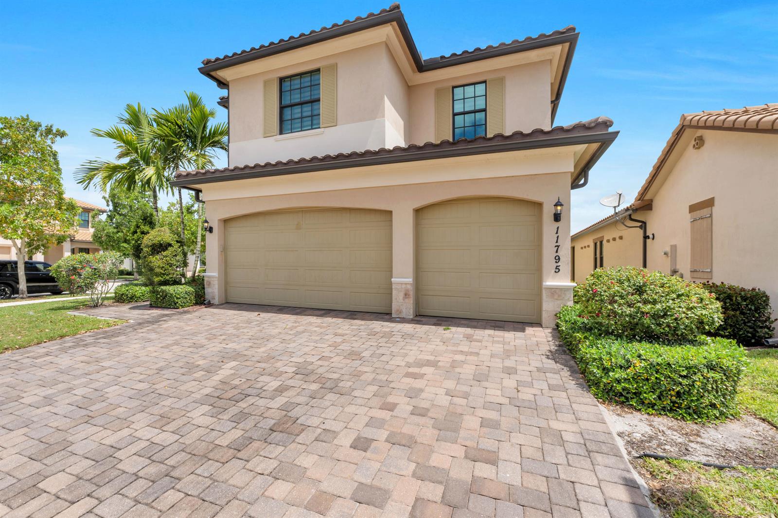 A two-story house with a two-car garage and a paved driveway under a blue sky — 11795 Waterway Circle, Parkland FL 33076, PARKLAND, FL