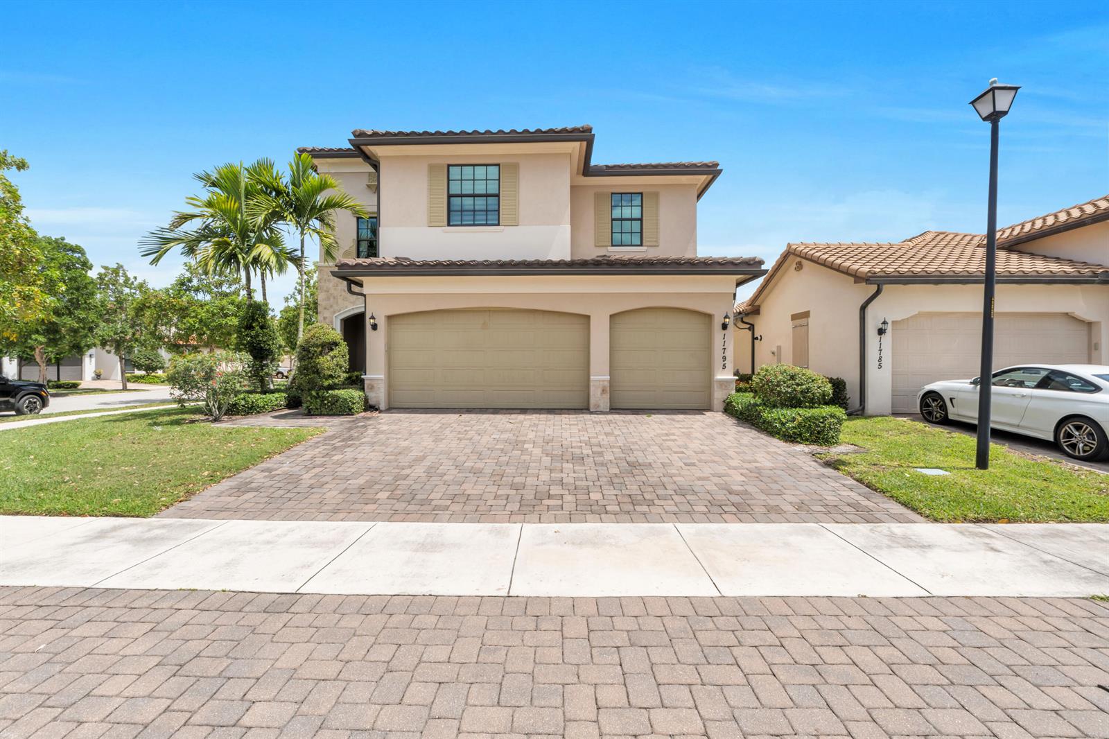 A two-story house with a two-car garage and a paved driveway under a blue sky — 11795 Waterway Circle, Parkland FL 33076, PARKLAND, FL