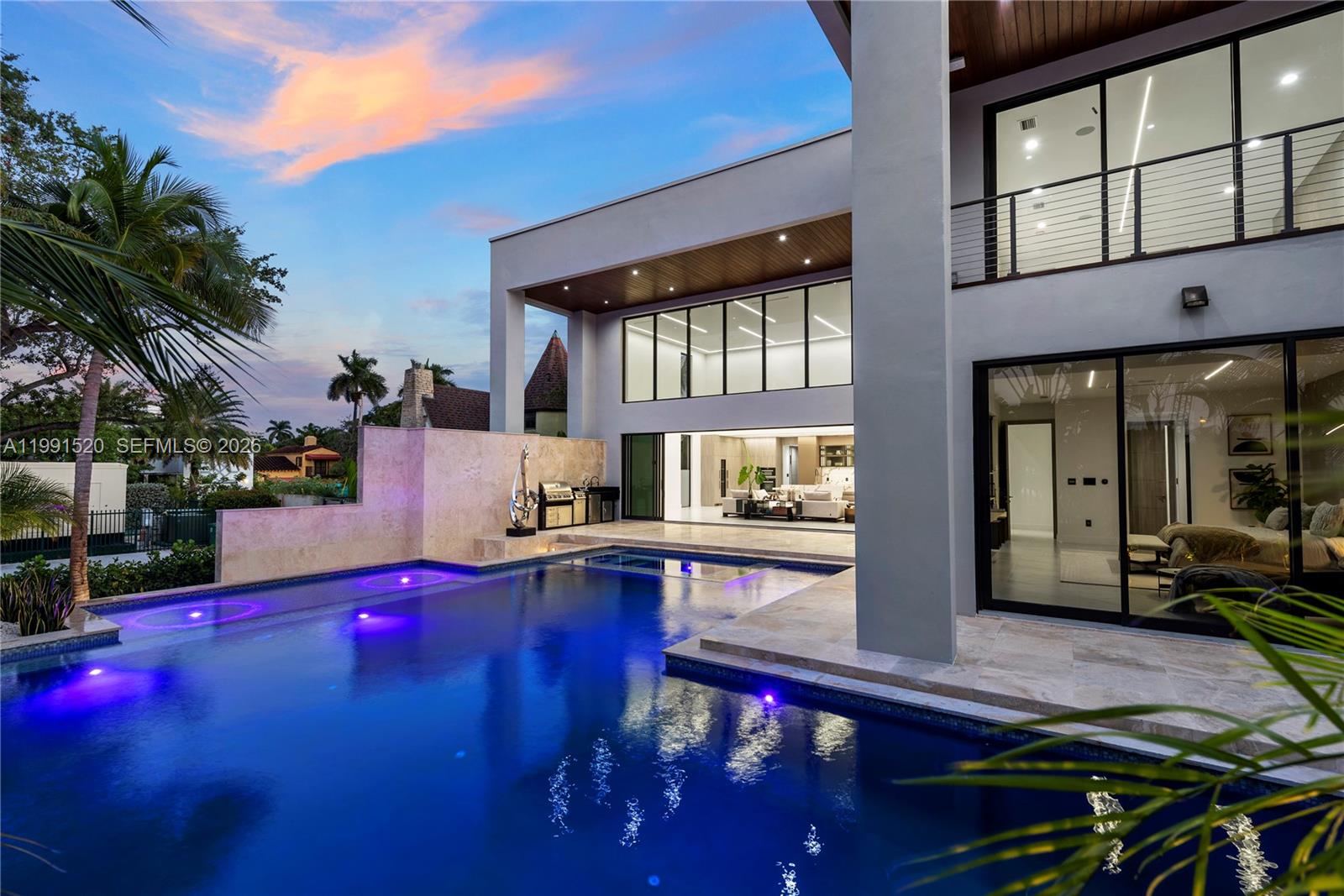 A modern two-story home features a swimming pool, outdoor kitchen, and large glass sliding doors — 775 NE 77th Ter, Miami FL 33138, MIAMI, FL