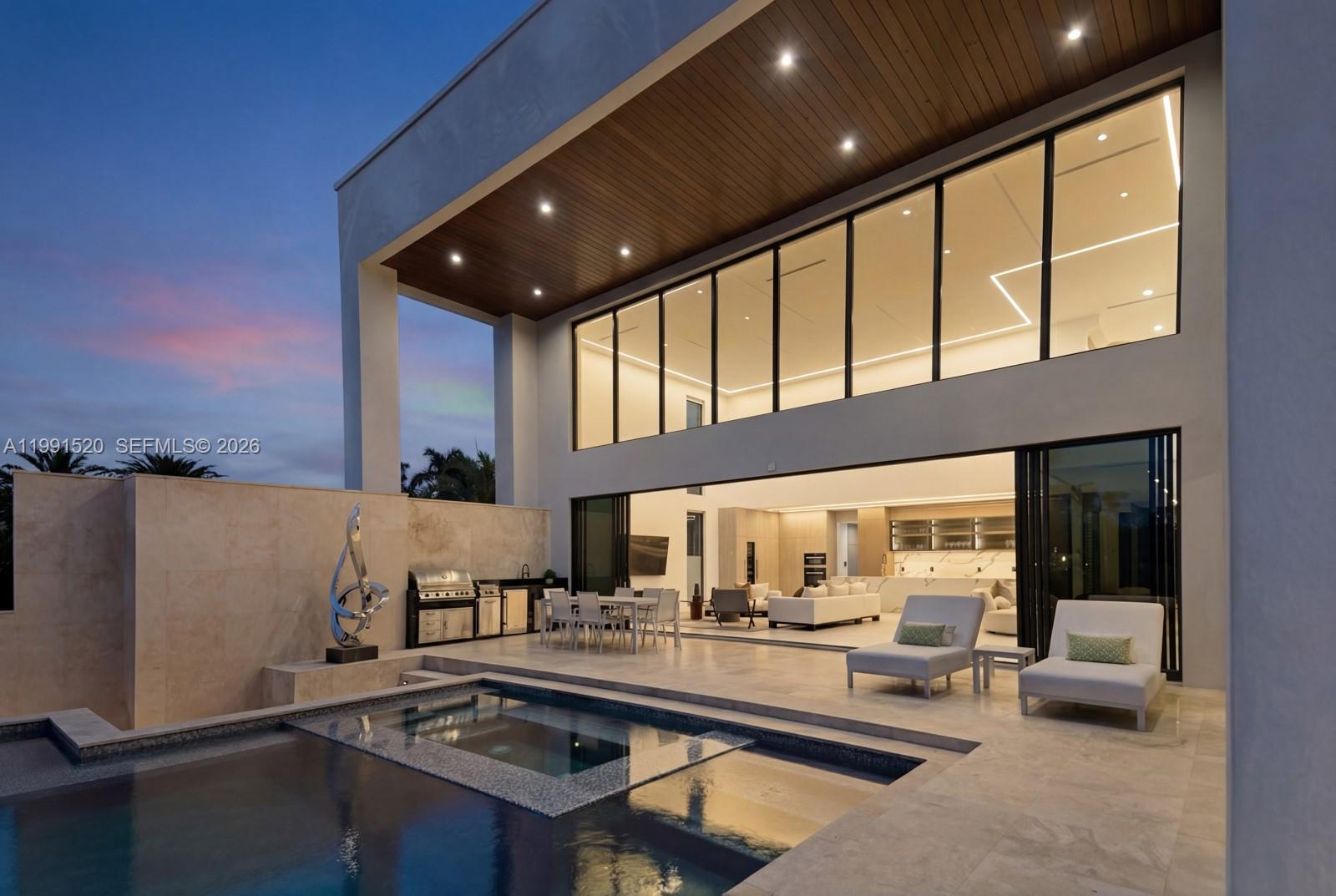 A modern two-story home features a pool, patio, outdoor kitchen, and large glass sliding doors — 775 NE 77th Ter, Miami FL 33138, MIAMI, FL