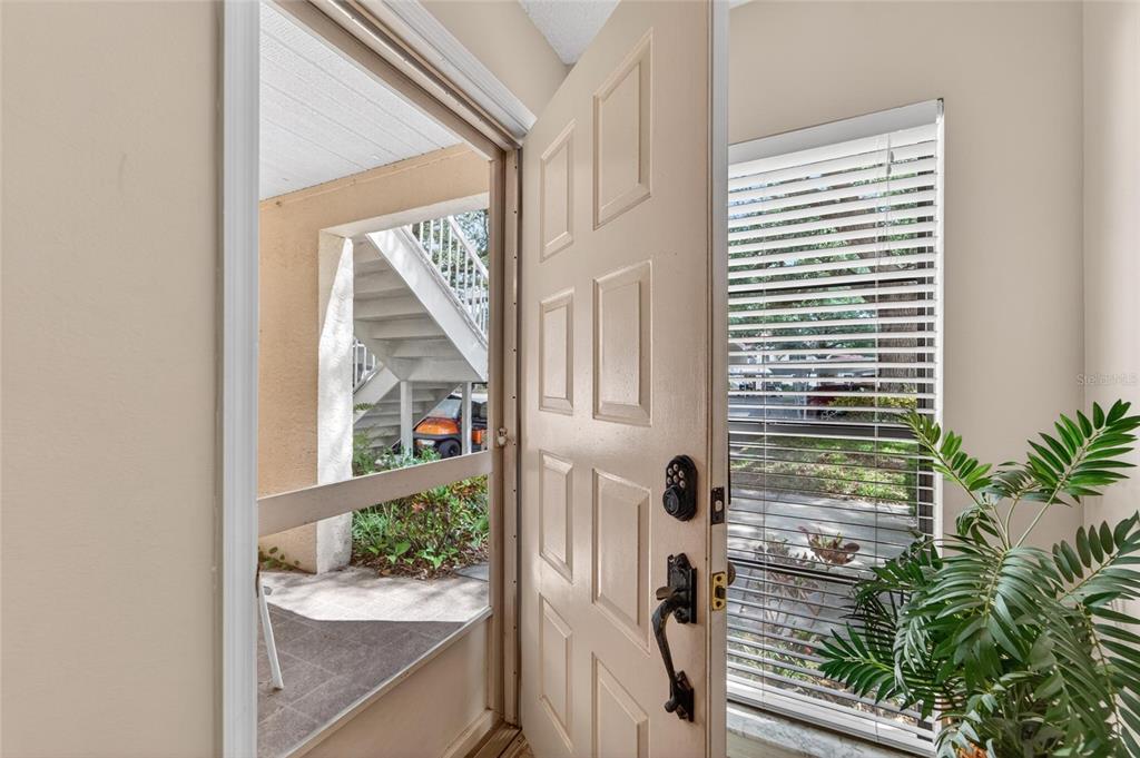 An open front door reveals a view of an outdoor staircase and a golf cart — 319 KNOTTWOOD COURT UNIT 2, SUN CITY CENTER, FL