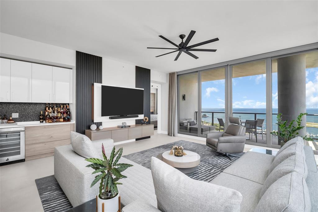 A modern living room features a gray sectional, a bar area, and floor-to-ceiling ocean views — 301 1ST STREET S UNIT 2501, ST PETERSBURG, FL