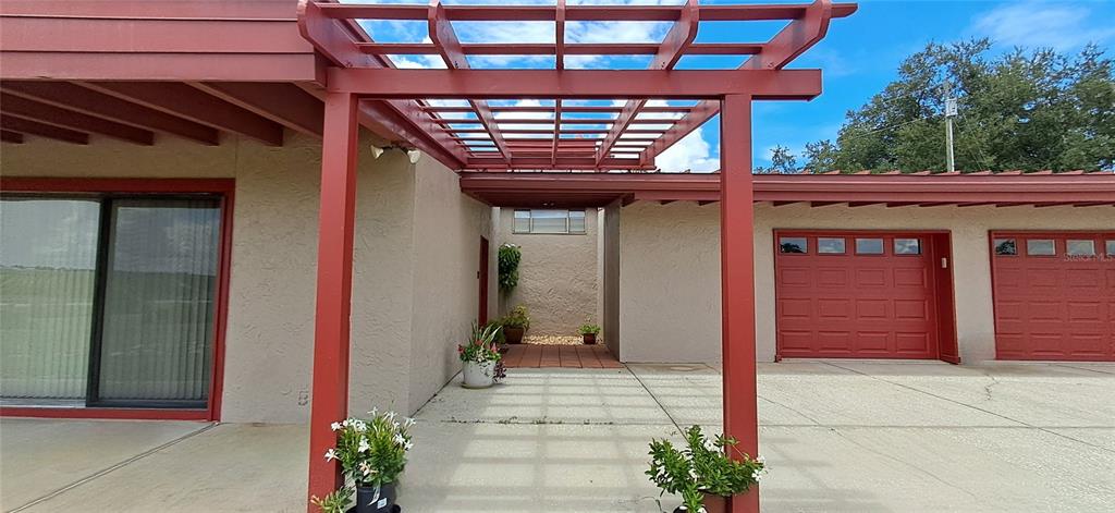A single-story house with a flat roof, red trim, sliding glass doors, and a garage — 2741 EDWARDS ROAD, HAINES CITY, FL