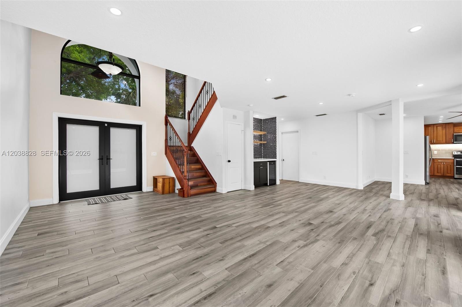 A spacious living area features wood-look flooring, a staircase, and a small wet bar — 11293 Rhapsody Rd # 0, Cooper City FL 33026, COOPER CITY, FL