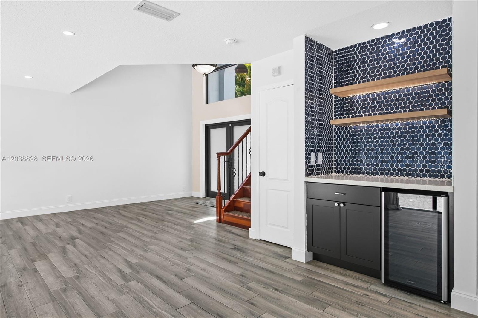 A room features gray wood-look flooring, a white door, and a wet bar area — 11293 Rhapsody Rd # 0, Cooper City FL 33026, COOPER CITY, FL
