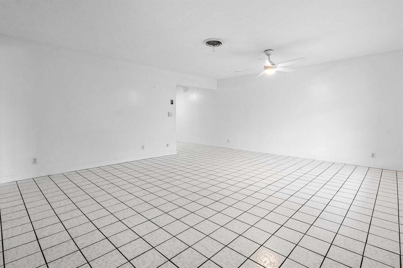 An empty room with white walls, a ceiling fan, and white tiled flooring — 11 Sailfish Lane, Ocean Ridge FL 33435, OCEAN RIDGE, FL
